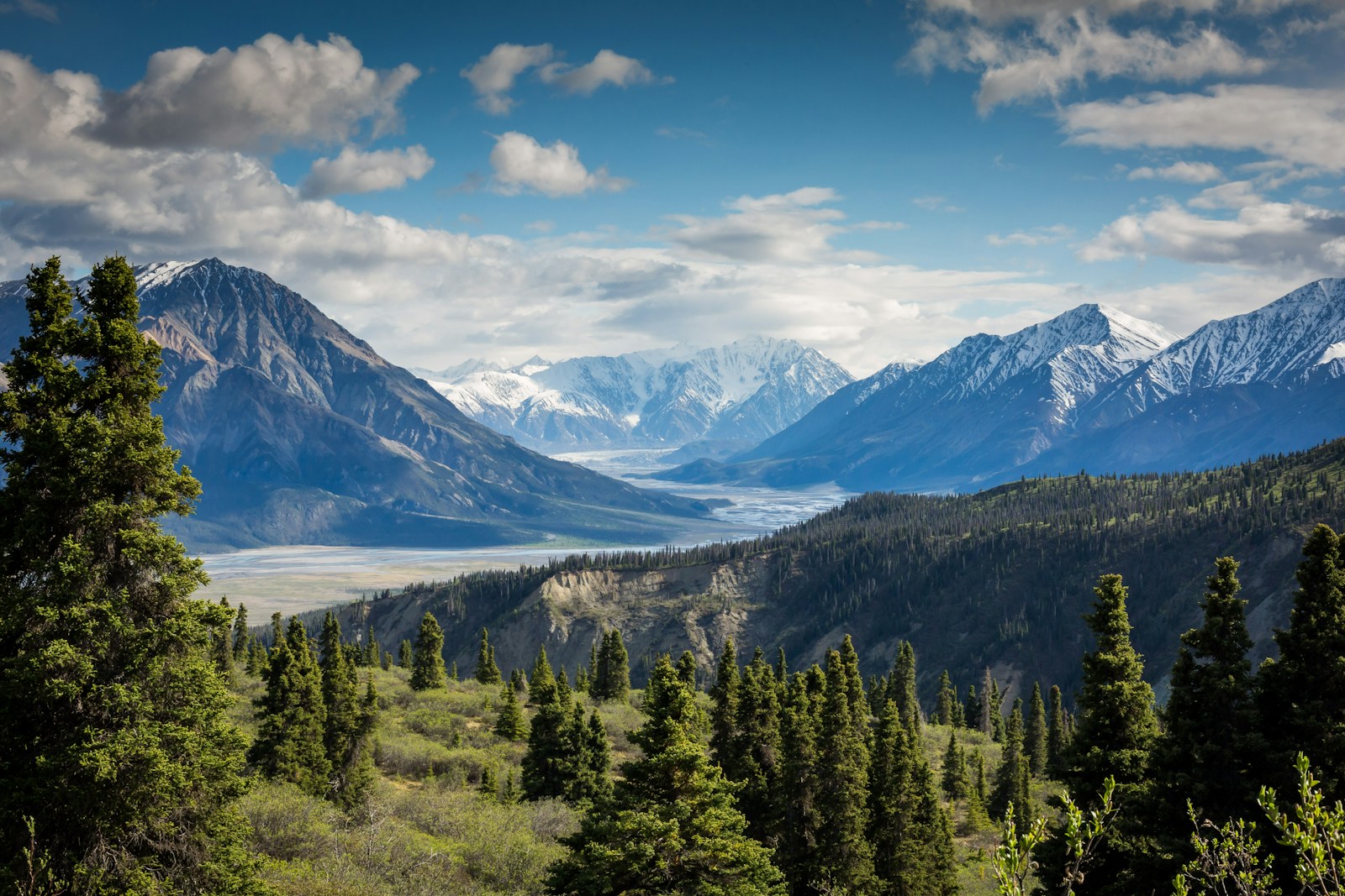 A mountain valley and lake beneath a cloudy sky